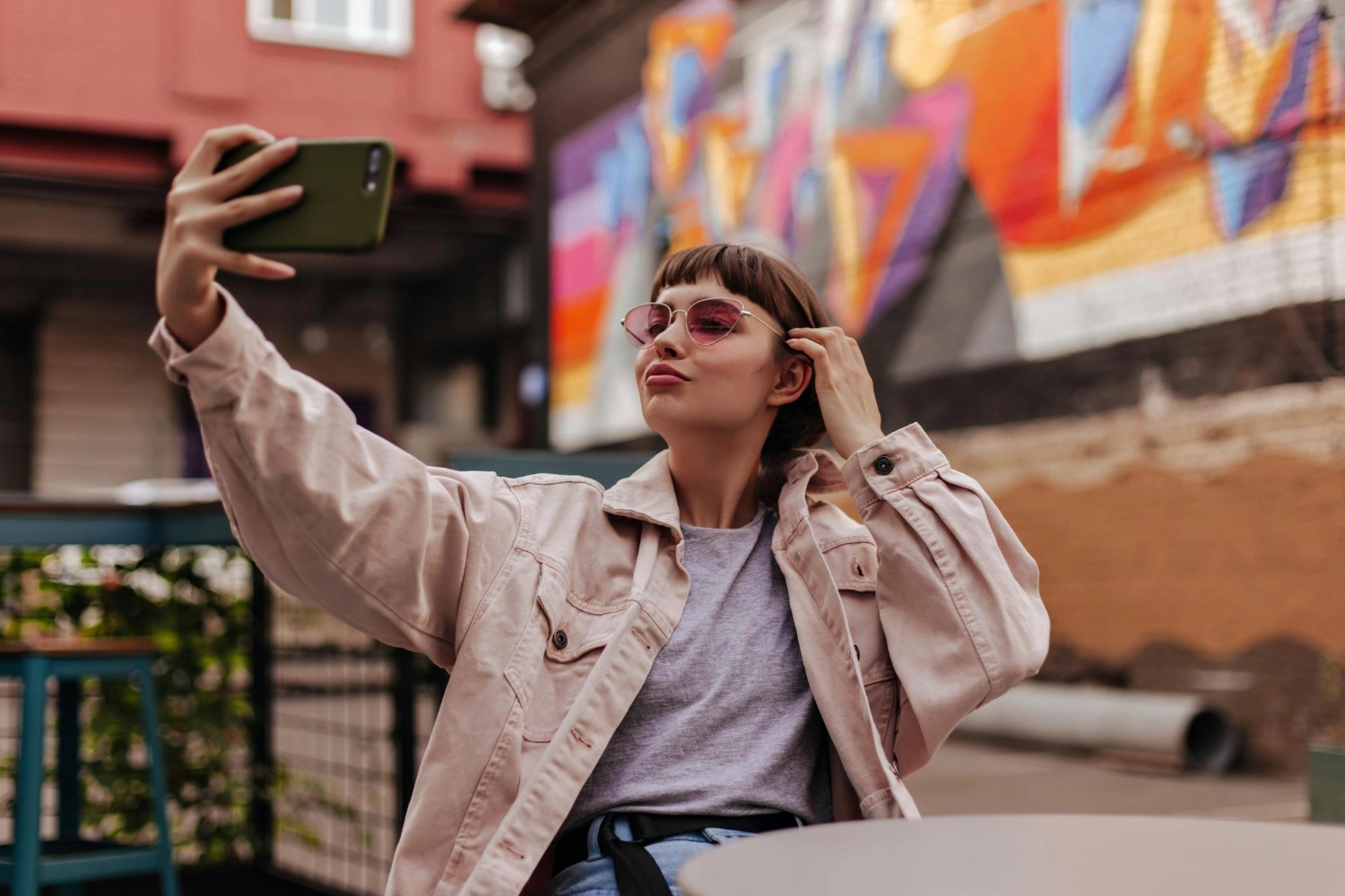 //webtech.international/wp-content/uploads/2023/08/hipster-brunette-girl-making-selfie-outdoors-shorthaired-woman-beige-jacket-pink-sunglasses-taking-photo-sitting-cafe.webp